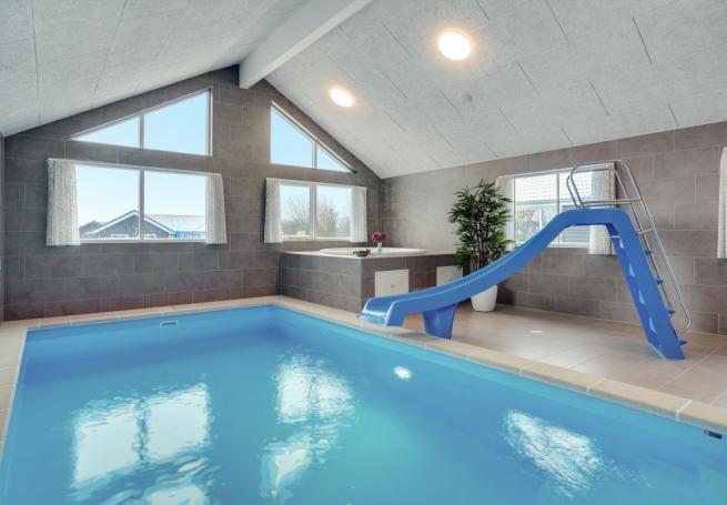 Das Ferienhaus 816 hat einen schicken Poolbereich mit Wasserrutsche, einem geräumigen, eingelassenen Whirlpool und einer Sauna.