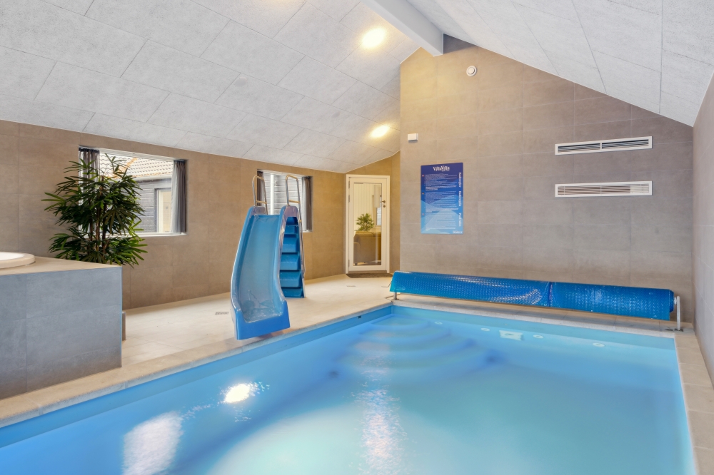 Das Ferienhaus 822 hat einen schicken Poolbereich mit Wasserrutsche, einem geräumigen, eingelassenen Whirlpool und einer Sauna.