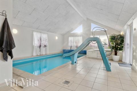 Das Ferienhaus 220 hat einen schicken Poolbereich mit Wasserrutsche, einem geräumigen, eingelassenen Whirlpool und einer Sauna.