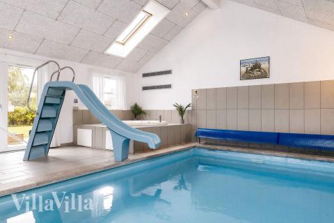 Das Ferienhaus 218 hat einen schicken Poolbereich mit Wasserrutsche, einem geräumigen, eingelassenen Whirlpool und einer Sauna.
