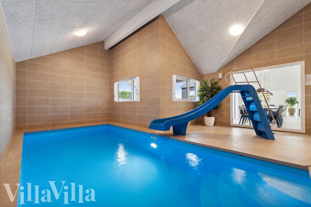 Das Ferienhaus 696 hat einen schicken Poolbereich mit Wasserrutsche, einem geräumigen, eingelassenen Whirlpool und einer Sauna.