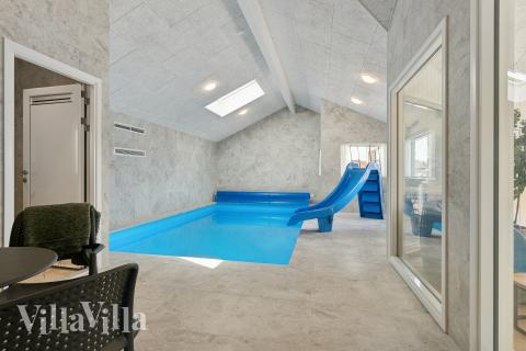 Das Ferienhaus 910 hat einen schicken Poolbereich mit Wasserrutsche, einem geräumigen, eingelassenen Whirlpool und einer Sauna.