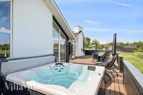 Genießen Sie den warmen Whirlpool im Luxusferienhaus Nr. 690 in Ostjütland