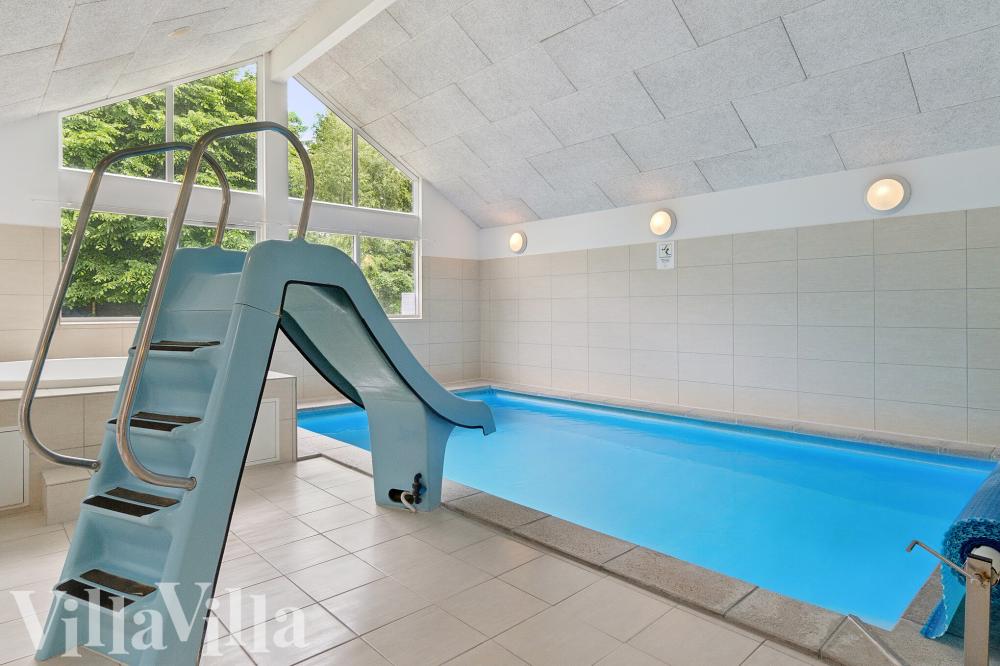 Das Ferienhaus 320 hat einen schicken Poolbereich mit Wasserrutsche, einem geräumigen, eingelassenen Whirlpool und einer Sauna.