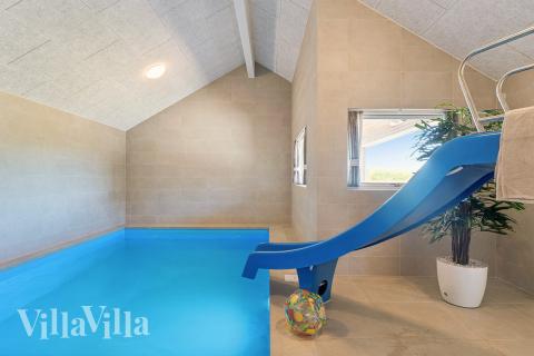 Das Ferienhaus 671 hat einen schicken Poolbereich mit Wasserrutsche, einem geräumigen, eingelassenen Whirlpool und einer Sauna.