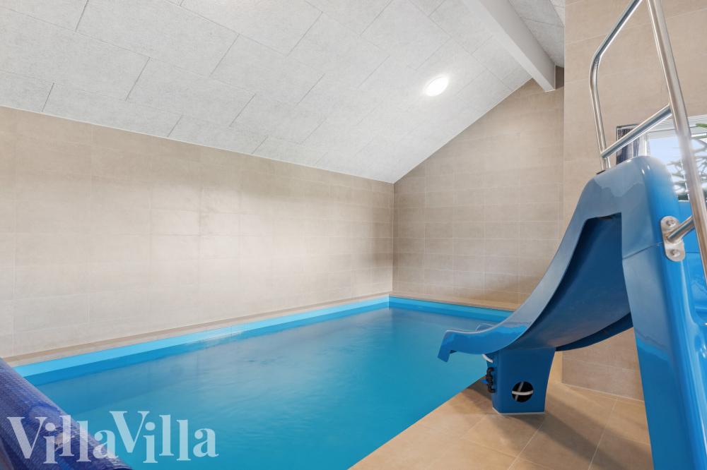 Das Ferienhaus 695 hat einen schicken Poolbereich mit Wasserrutsche, einem geräumigen, eingelassenen Whirlpool und einer Sauna.