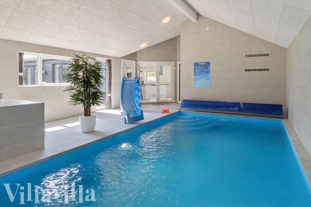 Das Ferienhaus 815 hat einen schicken Poolbereich mit Wasserrutsche, einem geräumigen, eingelassenen Whirlpool und einer Sauna.