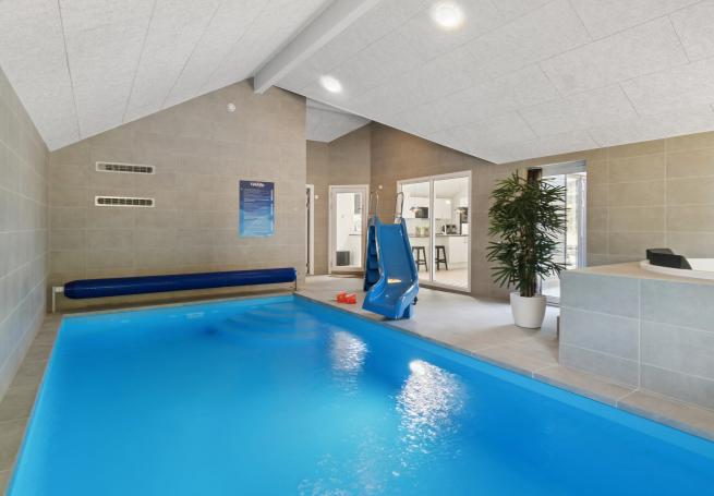 Das Ferienhaus 817 hat einen schicken Poolbereich mit Wasserrutsche, einem geräumigen, eingelassenen Whirlpool und einer Sauna.