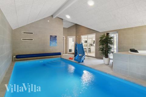 Das Ferienhaus 817 hat einen schicken Poolbereich mit Wasserrutsche, einem geräumigen, eingelassenen Whirlpool und einer Sauna.