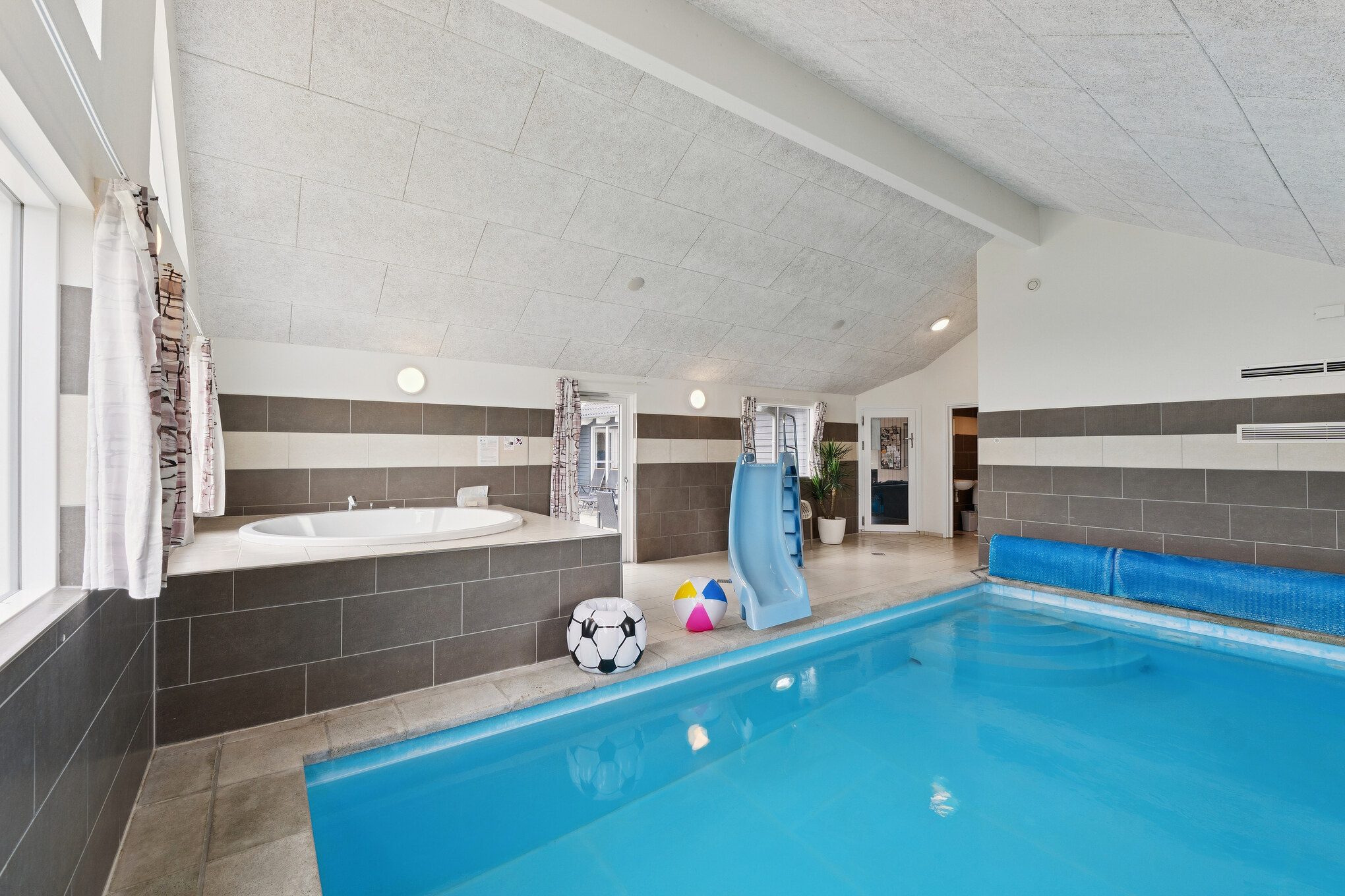 Das Ferienhaus 404 hat einen schicken Poolbereich mit Wasserrutsche, einem geräumigen, eingelassenen Whirlpool und einer Sauna.