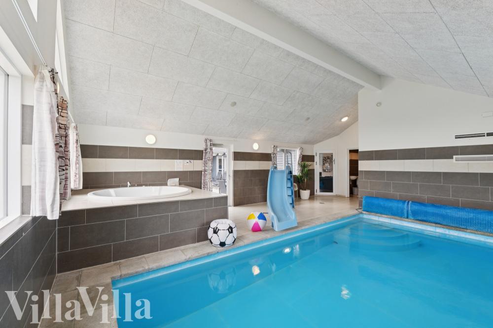 Das Ferienhaus 404 hat einen schicken Poolbereich mit Wasserrutsche, einem geräumigen, eingelassenen Whirlpool und einer Sauna.