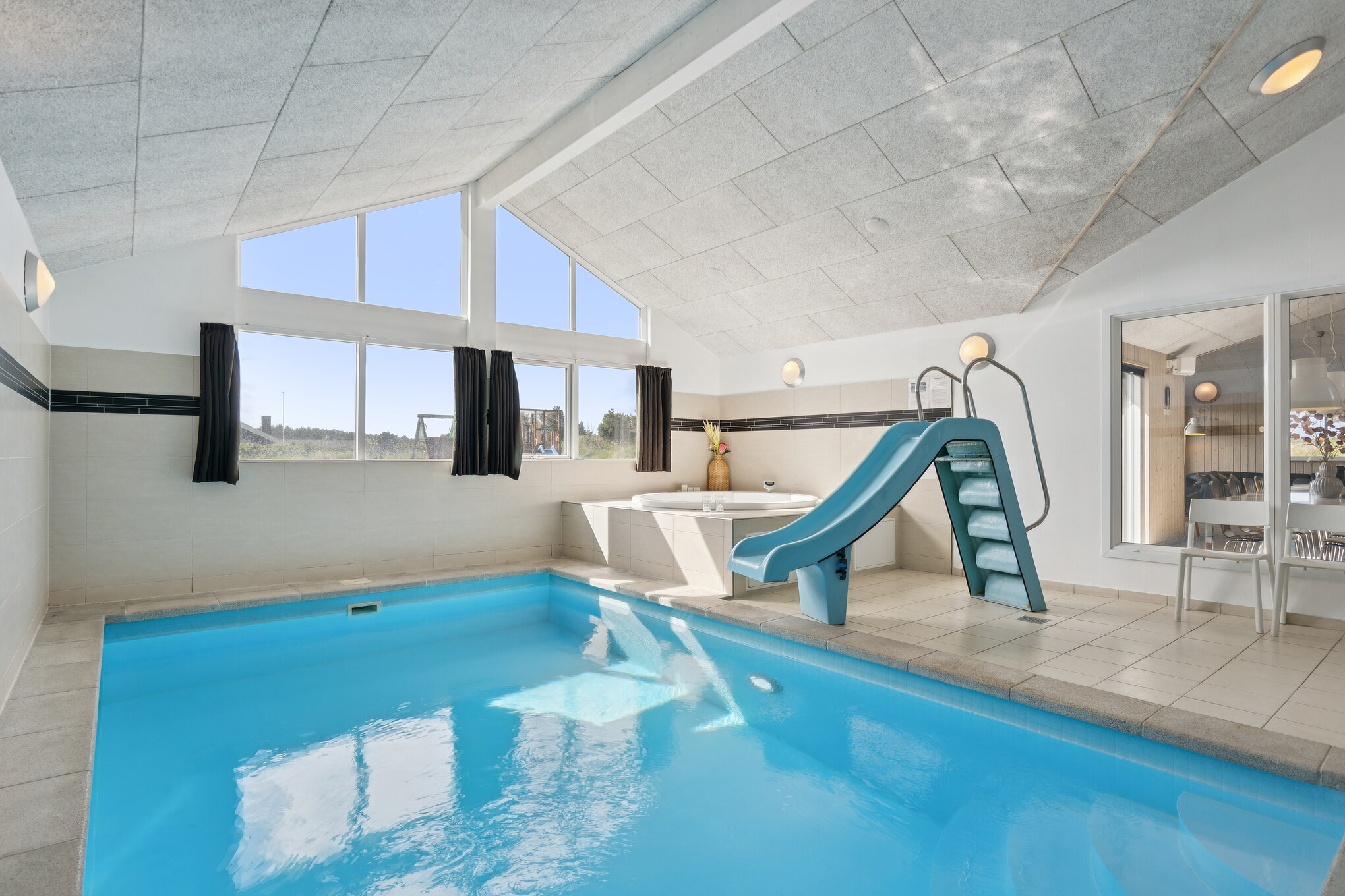 Das Ferienhaus 292 hat einen schicken Poolbereich mit Wasserrutsche, einem geräumigen, eingelassenen Whirlpool und einer Sauna.