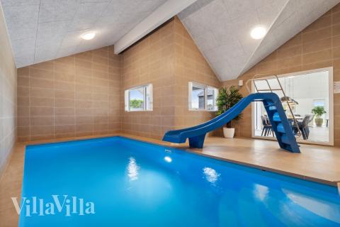 Das Ferienhaus 907 hat einen schicken Poolbereich mit Wasserrutsche, einem geräumigen, eingelassenen Whirlpool und einer Sauna.