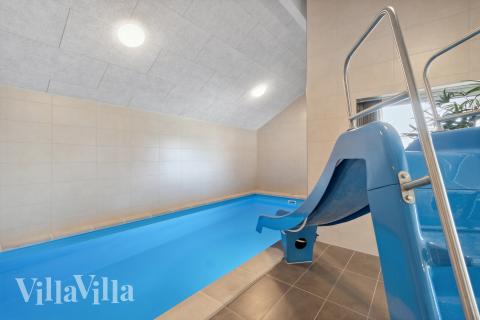 Das Ferienhaus 906 hat einen schicken Poolbereich mit Wasserrutsche, einem geräumigen, eingelassenen Whirlpool und einer Sauna.