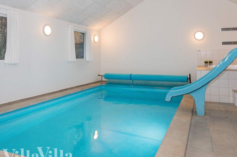 Das Ferienhaus 223 hat einen schicken Poolbereich mit Wasserrutsche, einem geräumigen, eingelassenen Whirlpool und einer Sauna.