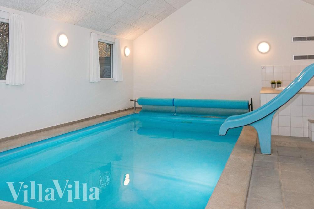 Das Ferienhaus 223 hat einen schicken Poolbereich mit Wasserrutsche, einem geräumigen, eingelassenen Whirlpool und einer Sauna.