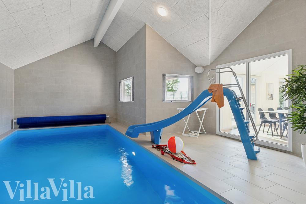 Das Ferienhaus 699 hat einen schicken Poolbereich mit Wasserrutsche, einem geräumigen, eingelassenen Whirlpool und einer Sauna.