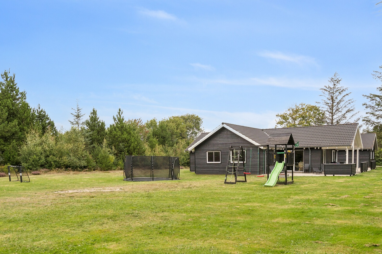 Zu dem attraktiven Ferienhaus Nr. 387 in Westjütland gehört auch ein tolles Angebot im Außenbereich, z. B. Spieleturm und Schaukeln