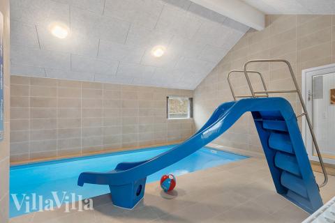 Das Ferienhaus 900 hat einen schicken Poolbereich mit Wasserrutsche, einem geräumigen, eingelassenen Whirlpool und einer Sauna.