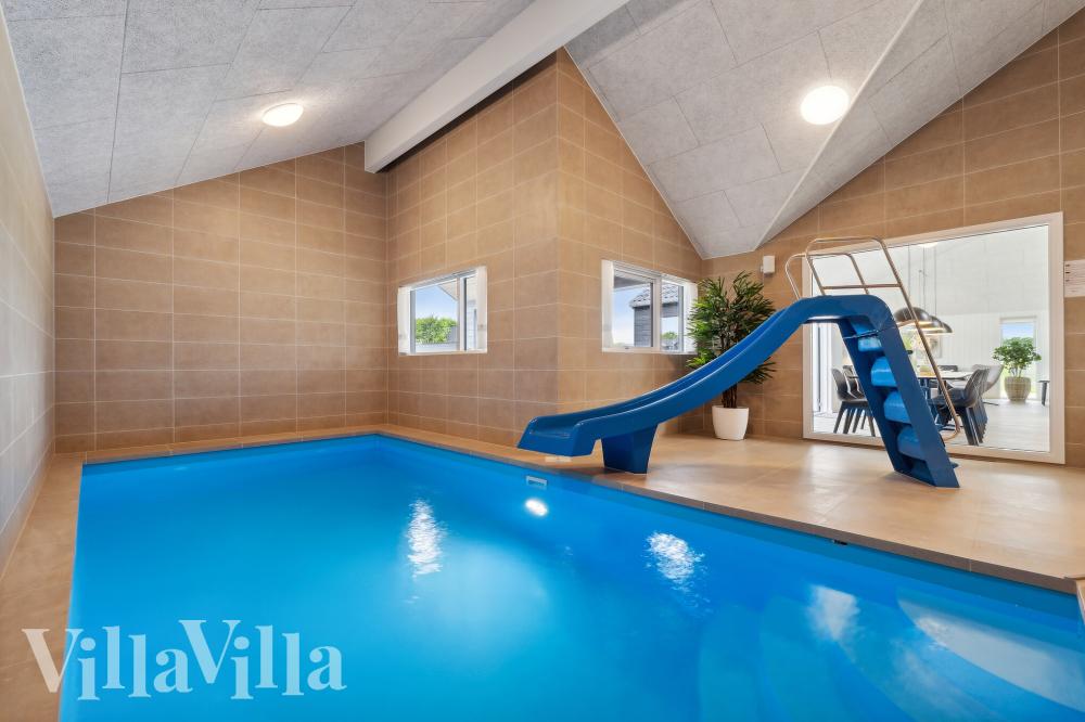 Das Ferienhaus 921 hat einen schicken Poolbereich mit Wasserrutsche, einem geräumigen, eingelassenen Whirlpool und einer Sauna.