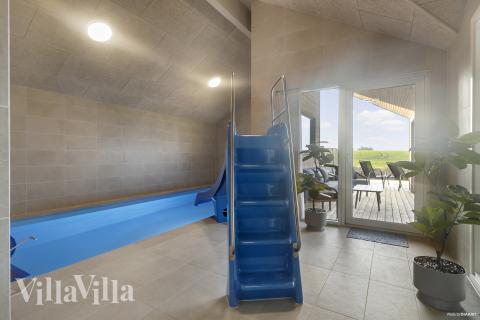 Das Ferienhaus 906 hat einen schicken Poolbereich mit Wasserrutsche, einem geräumigen, eingelassenen Whirlpool und einer Sauna.