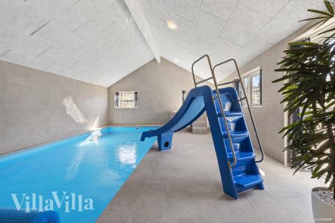 Das Ferienhaus 822 hat einen schicken Poolbereich mit Wasserrutsche, einem geräumigen, eingelassenen Whirlpool und einer Sauna.