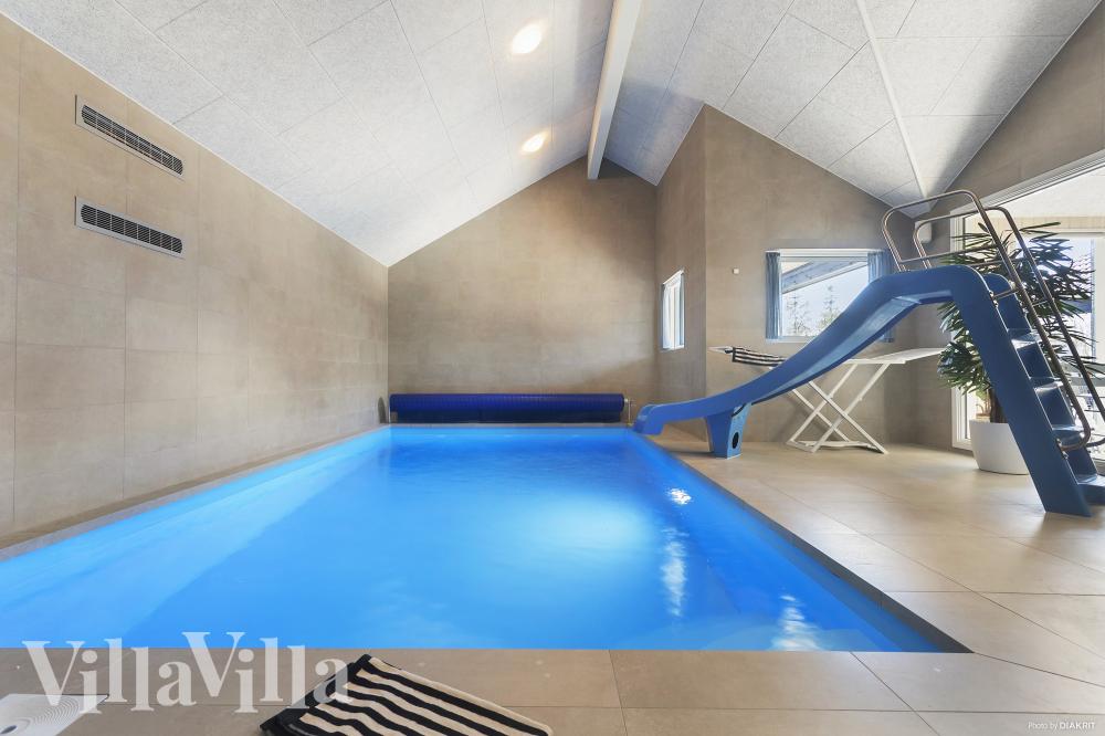 Das Ferienhaus 933 hat einen schicken Poolbereich mit Wasserrutsche, einem geräumigen, eingelassenen Whirlpool und einer Sauna.