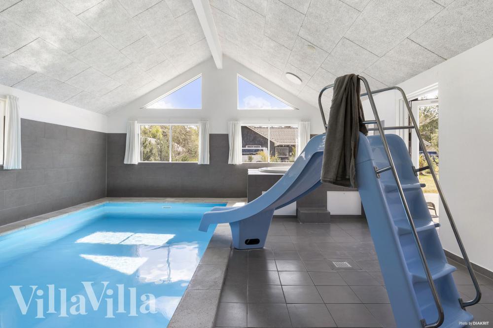 Das Ferienhaus 351 hat einen schicken Poolbereich mit Wasserrutsche, einem geräumigen, eingelassenen Whirlpool und einer Sauna.