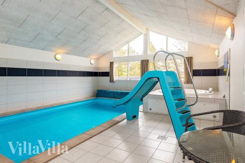 Das Ferienhaus 295 hat einen schicken Poolbereich mit Wasserrutsche, einem geräumigen, eingelassenen Whirlpool und einer Sauna.