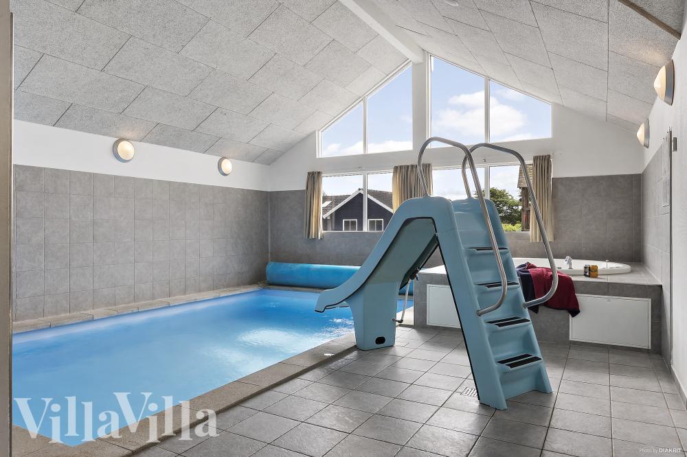 Das Ferienhaus 255 hat einen schicken Poolbereich mit Wasserrutsche, einem geräumigen, eingelassenen Whirlpool und einer Sauna.