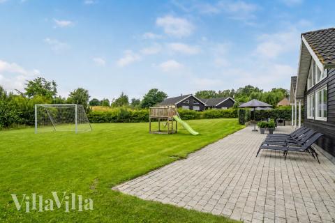 Zu dem attraktiven Ferienhaus Nr. 276 in Nordseeland gehört auch ein tolles Angebot im Außenbereich, z. B. Spieleturm und Schaukeln