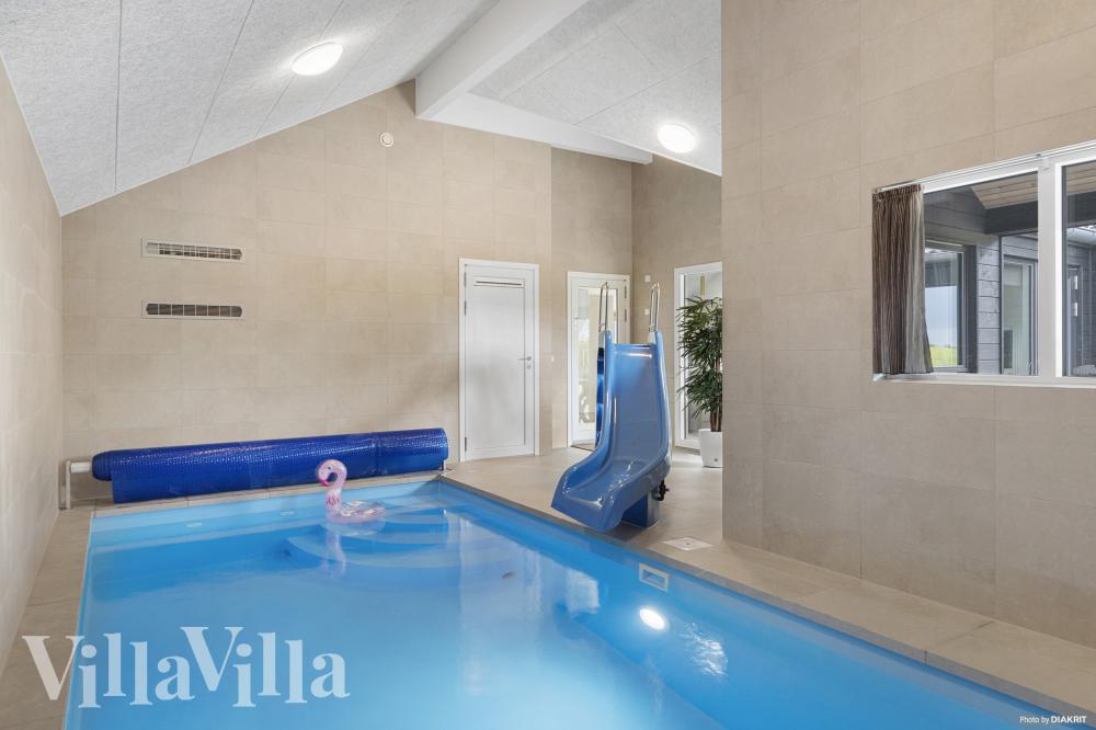 Das Ferienhaus 915 hat einen schicken Poolbereich mit Wasserrutsche, einem geräumigen, eingelassenen Whirlpool und einer Sauna.