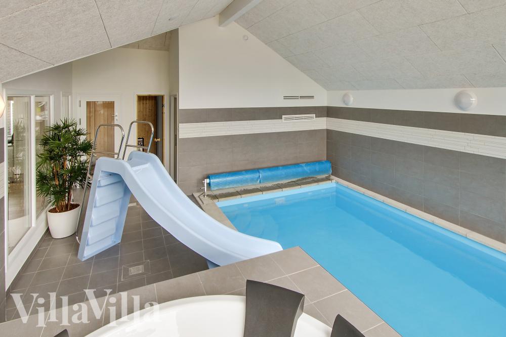 Das Ferienhaus 355 hat einen schicken Poolbereich mit Wasserrutsche, einem geräumigen, eingelassenen Whirlpool und einer Sauna.