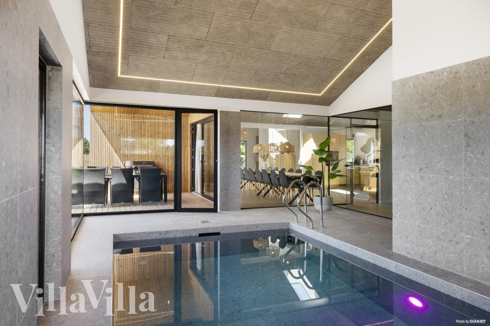 Das Ferienhaus 975 hat einen schicken Poolbereich mit Wasserrutsche, einem geräumigen, eingelassenen Whirlpool und einer Sauna.