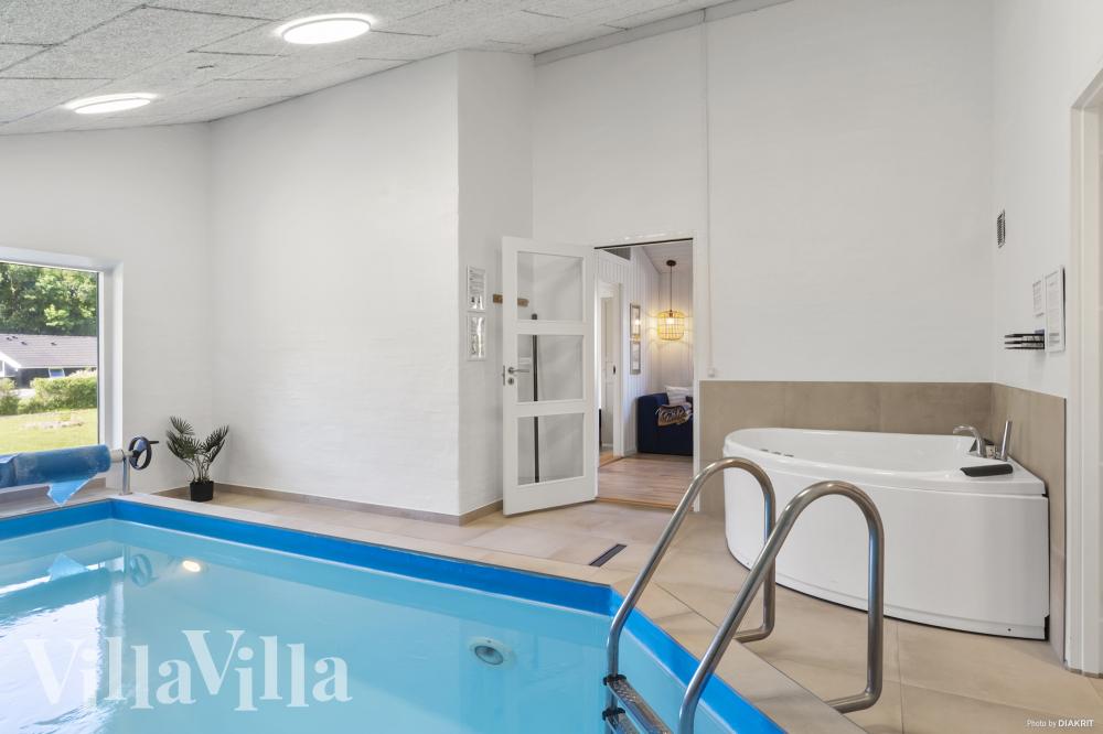Das Ferienhaus 980 hat einen schicken Poolbereich mit Wasserrutsche, einem geräumigen, eingelassenen Whirlpool und einer Sauna.