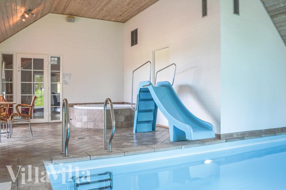 Das Ferienhaus 989 hat einen schicken Poolbereich mit Wasserrutsche, einem geräumigen, eingelassenen Whirlpool und einer Sauna.