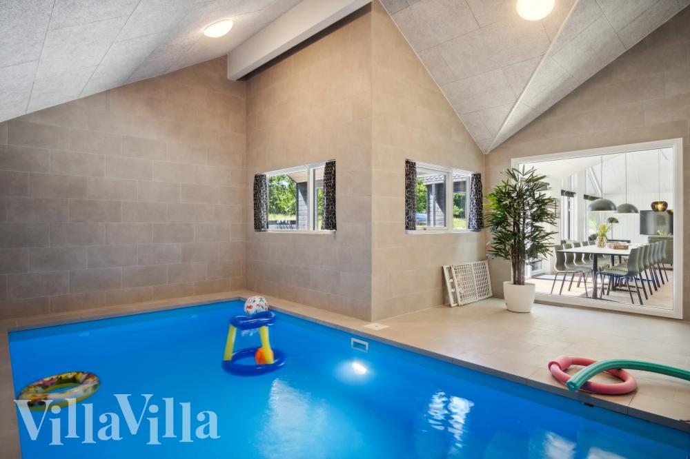Das Ferienhaus 999 hat einen schicken Poolbereich mit Wasserrutsche, einem geräumigen, eingelassenen Whirlpool und einer Sauna.