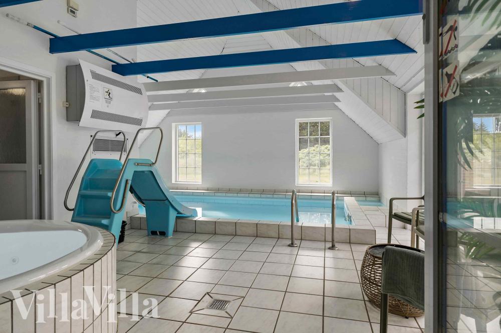 Das Ferienhaus 1005 hat einen schicken Poolbereich mit Wasserrutsche, einem geräumigen, eingelassenen Whirlpool und einer Sauna.