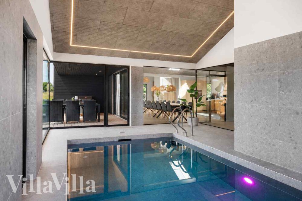 Das Ferienhaus 1023 hat einen schicken Poolbereich mit Wasserrutsche, einem geräumigen, eingelassenen Whirlpool und einer Sauna.