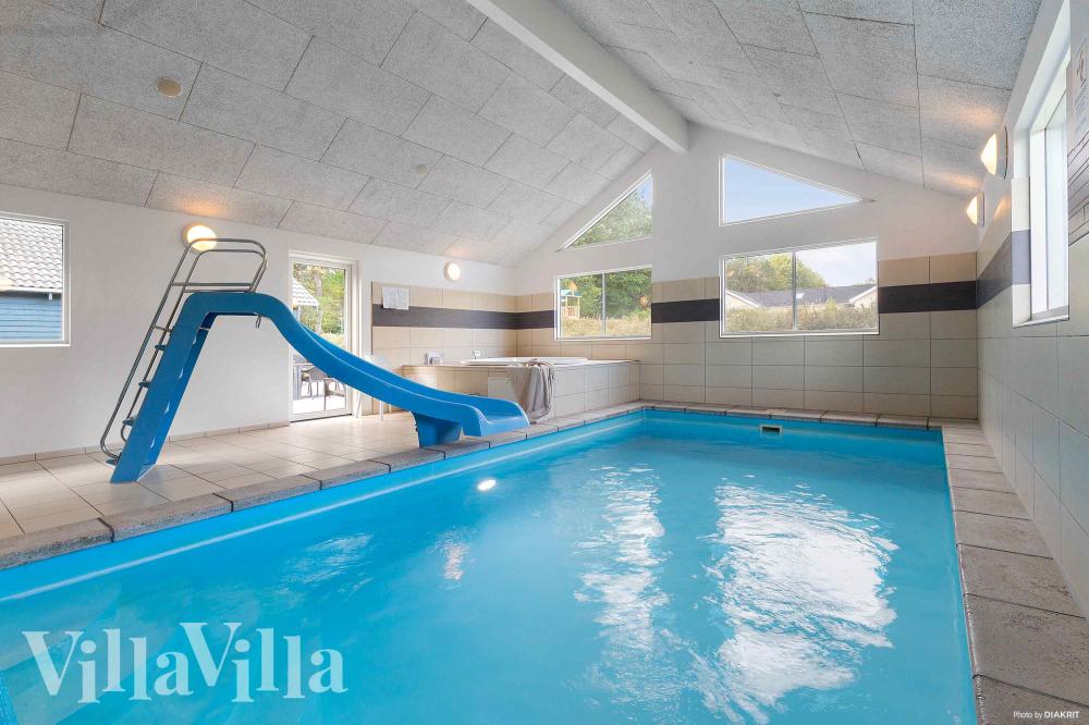 Das Ferienhaus 335 hat einen schicken Poolbereich mit Wasserrutsche, einem geräumigen, eingelassenen Whirlpool und einer Sauna.