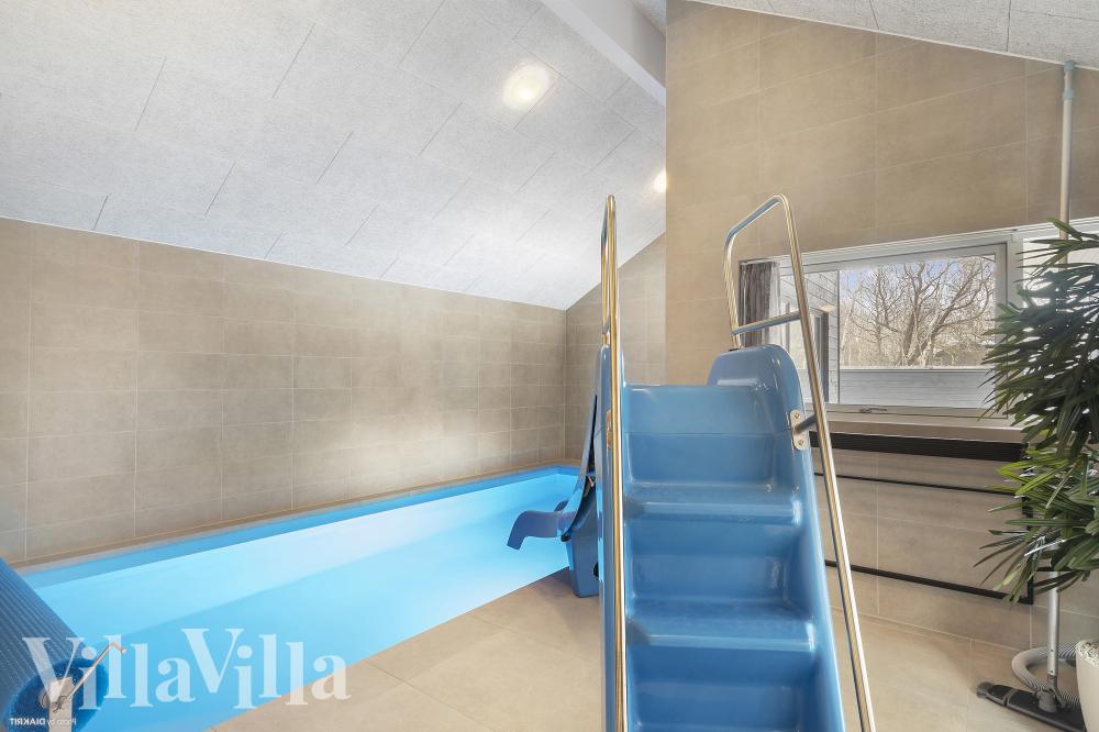 Das Ferienhaus 1021 hat einen schicken Poolbereich mit Wasserrutsche, einem geräumigen, eingelassenen Whirlpool und einer Sauna.